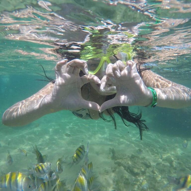 Turista aproveitando um mergulho nas praias de Salvador e apaixonada pela Gran Turismo